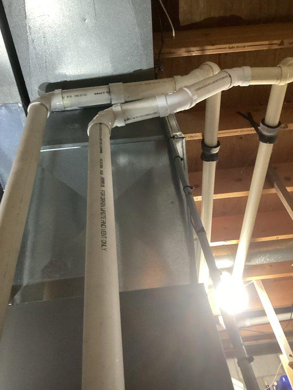 Performed routine tune-up service on residential HVAC system, inspecting the furnace/air handler unit and associated PVC ventilation pipes. Checked all connections on both the HVAC components and adjacent plumbing system, confirming proper installation and functionality of all components. No issues were identified during the inspection.