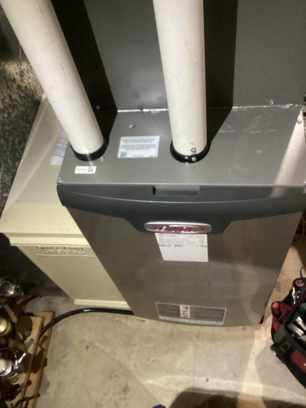 Performed routine tune-up service on residential HVAC system, inspecting the furnace/air handler unit and associated PVC ventilation pipes. Checked all connections on both the HVAC components and adjacent plumbing system, confirming proper installation and functionality of all components. No issues were identified during the inspection.
