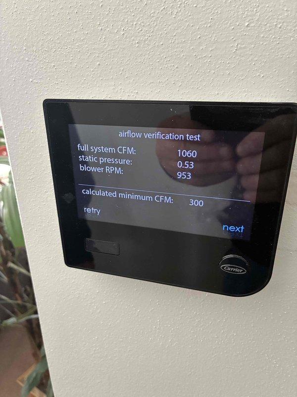 Performed airflow verification testing on Carrier HVAC system that was experiencing heating issues. Initial test readings showed full system CFM at 1060 with static pressure of 0.53 and blower RPM at 953. Secondary test revealed increased static pressure (1.52) and excessive blower RPM (1310), indicating restricted airflow. Replaced clogged air filter and adjusted duct configuration to resolve the airflow restriction that was preventing proper heating operation.