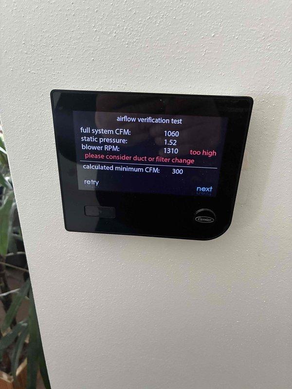 Performed airflow verification testing on Carrier HVAC system that was experiencing heating issues. Initial test readings showed full system CFM at 1060 with static pressure of 0.53 and blower RPM at 953. Secondary test revealed increased static pressure (1.52) and excessive blower RPM (1310), indicating restricted airflow. Replaced clogged air filter and adjusted duct configuration to resolve the airflow restriction that was preventing proper heating operation.