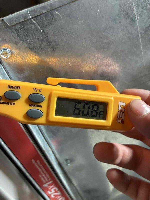 Completed routine tune-up service on customer's HVAC system. Performed temperature readings using digital thermometer, recording 60.8°F at supply register. Inspected internal components and warning labels for proper operation and safety compliance.