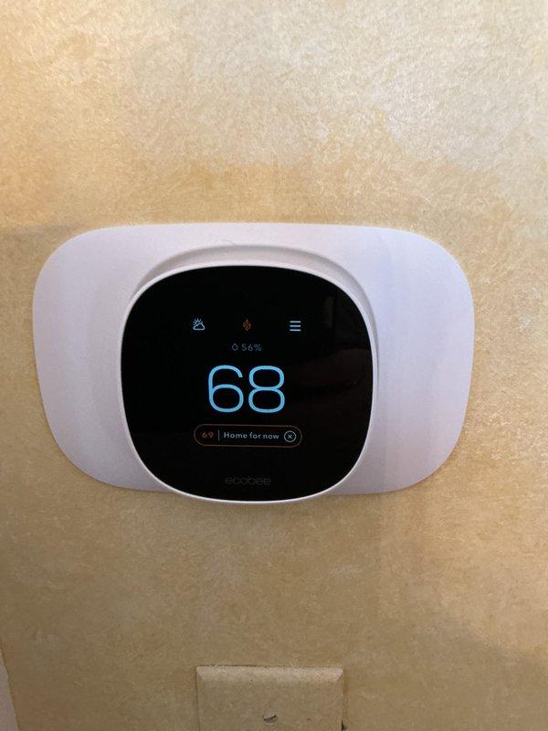 Installed and configured ecobee smart thermostat system. Set initial temperature to 68°F and verified proper display functioning. Confirmed home occupancy mode is operational with battery level reading at 56%.