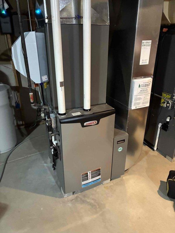 Performed comprehensive tune-up service on Lennox HVAC system located in utility area. Inspected furnace unit, vertical PVC exhaust pipes, and connected ductwork for proper installation and operation. System appears to be in good working condition with clean, professional installation and appropriate venting.