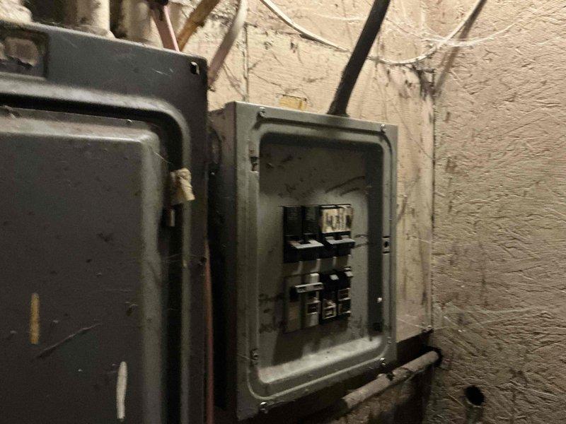 Performed inspection of electrical panels related to HVAC system replacement assessment. Examined two breaker panels showing signs of age and wear. Documented existing circuit configuration, including labeled water heater and furnace connections. Panels exhibited normal deterioration consistent with older installation but remain functional. Photos taken for electrical load capacity evaluation prior to equipment selection and installation planning.