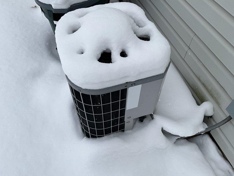 Conducted evaluation of HVAC system showing significant winter damage with outdoor unit completely obstructed by heavy snow accumulation, compromising airflow and operational efficiency. Inspection of interior components revealed existing plumbing connections with insulated piping and PVC drainage that will require proper integration during replacement. Recommended full system replacement to restore heating and cooling functionality with properly sized equipment and improved installation configuration to prevent future weather-related failures.