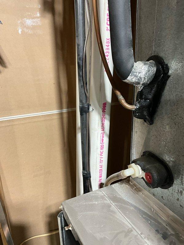 Conducted evaluation of HVAC system showing significant winter damage with outdoor unit completely obstructed by heavy snow accumulation, compromising airflow and operational efficiency. Inspection of interior components revealed existing plumbing connections with insulated piping and PVC drainage that will require proper integration during replacement. Recommended full system replacement to restore heating and cooling functionality with properly sized equipment and improved installation configuration to prevent future weather-related failures.