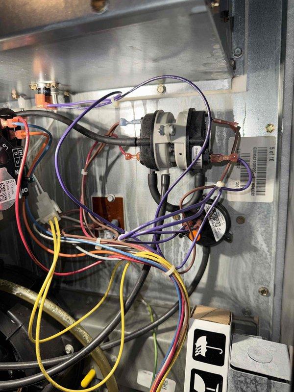 Diagnosed and repaired failed heat exchanger in furnace showing significant rust and corrosion around burner ports. Replaced primary heat exchanger assembly and verified proper operation of electrical components including pressure switch and wiring connections. System now functioning within manufacturer specifications with normal heat output.