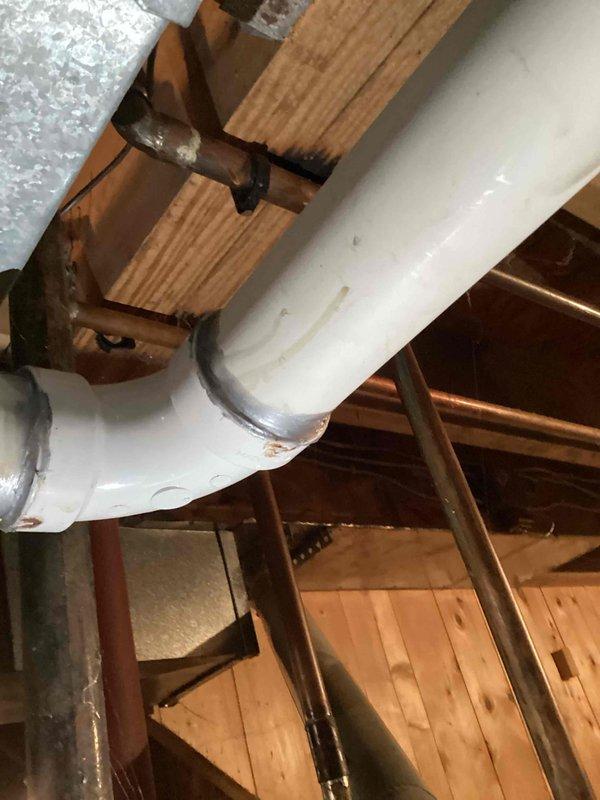 Inspected and documented plumbing infrastructure in attic/crawlspace area. Verified proper installation of PVC drainage system connected to copper supply lines. Confirmed all pipe supports and fasteners were secure with no visible leaks at connection points.