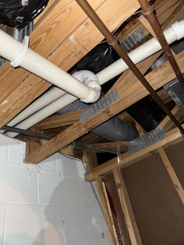 Conducted inspection of existing HVAC system in basement area. Assessed condition of current furnace/air handler unit with connected galvanized ductwork. Evaluated existing PVC venting system running through floor joists and Space-Gard air cleaner. Provided estimate for complete system replacement based on observed installation requirements and spatial constraints.