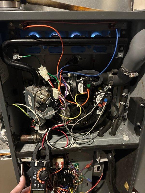 Responded to no-heat complaint on aging furnace. Performed diagnostic testing with multimeter, measuring 0.22 amps on the inducer motor. Verified gas valve operation and inspected flame pattern, which showed proper blue flames across all four burners. System is now operating correctly with restored heat output.