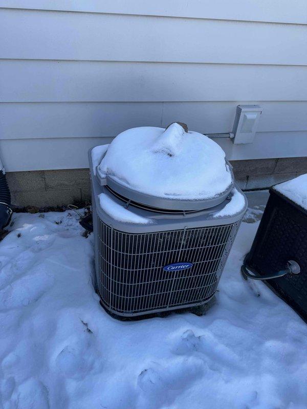 Performed comprehensive HVAC system replacement, installing new Carrier equipment including indoor furnace unit with updated control board and motor assembly. Completed installation of properly sealed metal ductwork with insulated connections and Y-joint distribution system. Positioned outdoor condensing unit on concrete pad with proper clearance from house structure, noting winter conditions necessitate protective measures for the outdoor equipment.