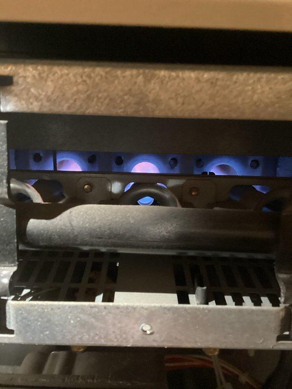 Conducted inspection of furnace system with focus on electrical connections and burner assembly. Verified proper electrical cord connections to main power outlet terminal. Confirmed normal flame pattern with consistent blue coloration across all burners, indicating complete combustion and proper gas-air mixture.
