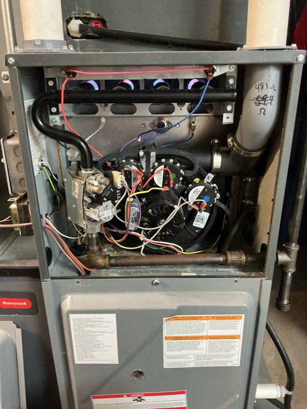 Performed comprehensive tune-up on Honeywell HVAC system, inspecting furnace interior components including blower motor, gas valve assembly, and electrical connections. Examined wiring integrity and connection points on the gas valve, noting normal wear but confirming proper functionality. All components were verified to be in working order with no significant issues detected.