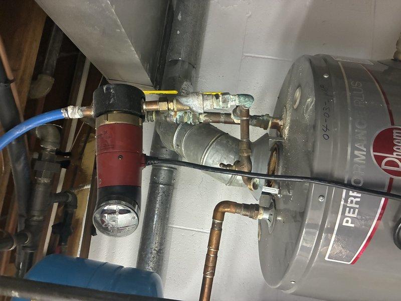 Performed installation of two tanked water heaters with proper copper piping connections. System includes a blue expansion tank, temperature and pressure relief valves, and necessary control valves including a prominent yellow handle valve. Observed minor corrosion on some copper fittings. All components were verified to be functioning correctly with no leaks detected.