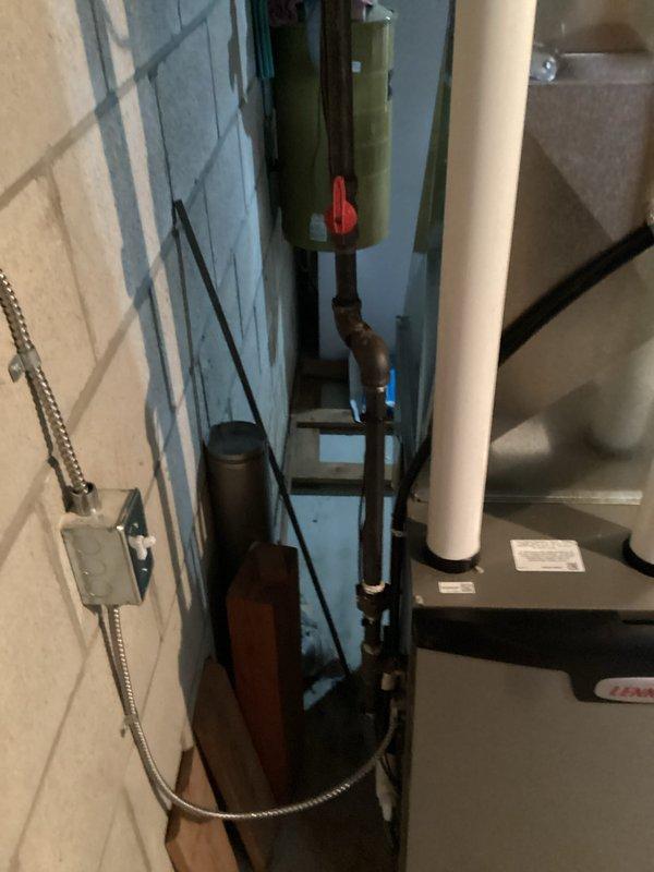 Completed installation of new gray furnace in confined utility room with proper connections to existing plumbing infrastructure. Installed white PVC exhaust venting and addressed moisture issues evident in concrete floor. Ensured all electrical connections were properly secured and system functioning according to specifications.