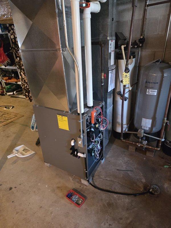 Installed new furnace unit with proper connection to existing ductwork and ventilation system. Performed electrical wiring installation and conducted diagnostic testing with digital measurement tool, confirming proper system operation with readings at 45.8. Completed installation with all necessary connections to home's mechanical systems including proper venting through PVC piping.