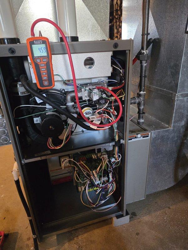 Installed new furnace unit with proper connection to existing ductwork and ventilation system. Performed electrical wiring installation and conducted diagnostic testing with digital measurement tool, confirming proper system operation with readings at 45.8. Completed installation with all necessary connections to home's mechanical systems including proper venting through PVC piping.