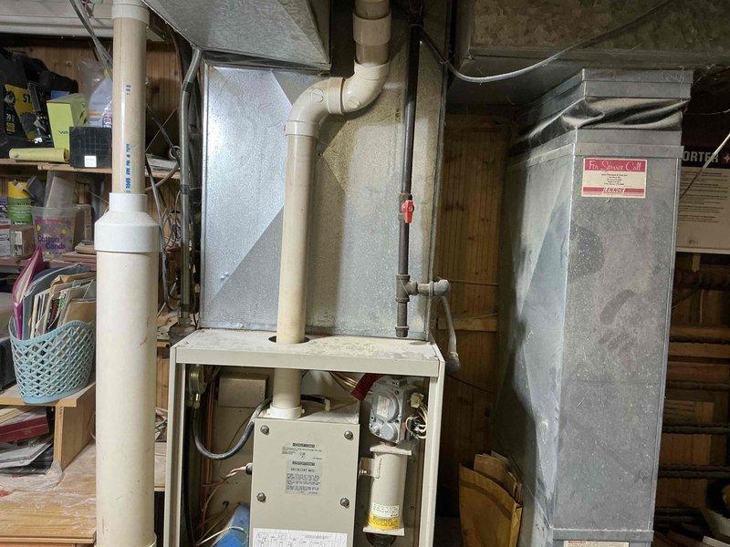 Performed comprehensive inspection of existing HVAC system in basement area. Evaluated electrical panel capacity and breaker configuration to ensure compatibility with potential replacement unit. Documented current installation including furnace unit with PVC venting, air handler with associated ductwork, and condensate drainage system. Assessment indicates system is properly installed but replacement options were presented to homeowner based on age and efficiency considerations of current equipment.