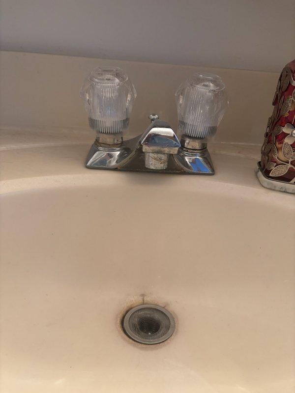 Installed new waterfall-style matte black bathroom faucet, replacing existing three-piece fixture. Connected supply lines and verified proper water flow and drainage functionality with no leaks present.