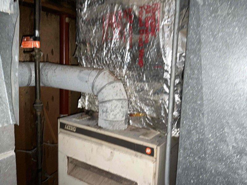 Performed inspection of GE electrical panel showing signs of age and wear. Panel has main breaker with handwritten circuit directory and visible wiring extending from top. Adjacent Lennox HVAC system was noted with insulated ductwork and associated piping. No electrical modifications were made at this time; assessment completed for future fixture and outlet installation planning.