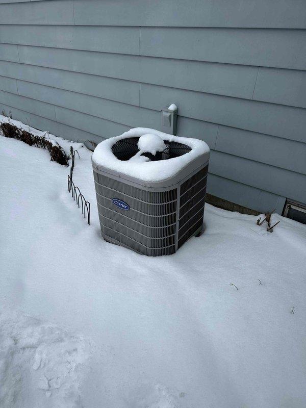 Performed site assessment of existing snow-covered Carrier outdoor condenser unit exhibiting signs of age and potential inefficiency. Recommended full system replacement based on observed condition, including accumulated snow on unit which may indicate poor heat transfer and reduced system performance. Documented current installation location adjacent to house with proper electrical disconnect in place for reference during replacement planning.