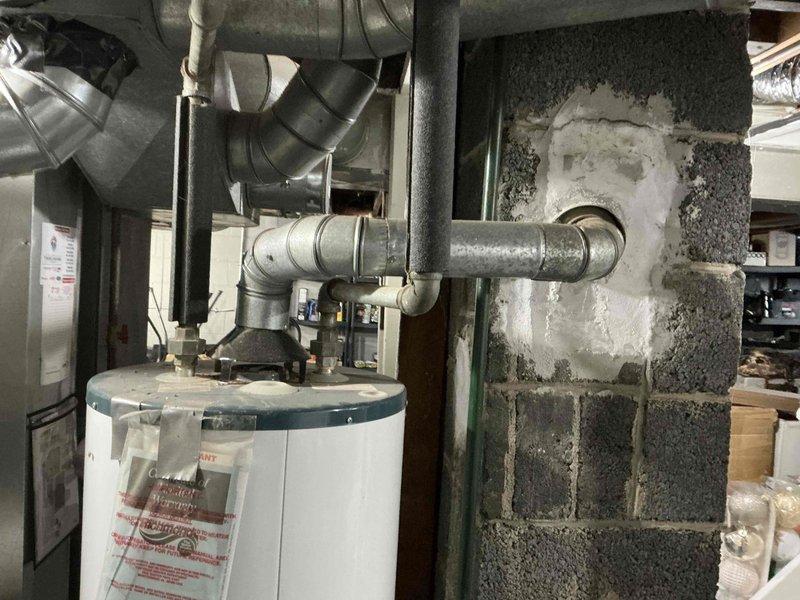 Conducted inspection of existing HVAC system in utility area, documenting aging ductwork, water heater connections, and associated plumbing infrastructure. Identified several sections of galvanized metal ducts with multiple bends and joints showing signs of deterioration, along with plumbing components exhibiting minor corrosion at connection points. Recommended full system replacement to address efficiency concerns and prevent potential future failures.