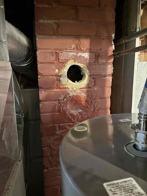 Inspected brick wall passthrough for HVAC system and evaluated ventilation integrity around water heater installation. Conducted diagnostic testing with digital pressure gauge to verify proper system operation and ensure compliance with ventilation requirements.