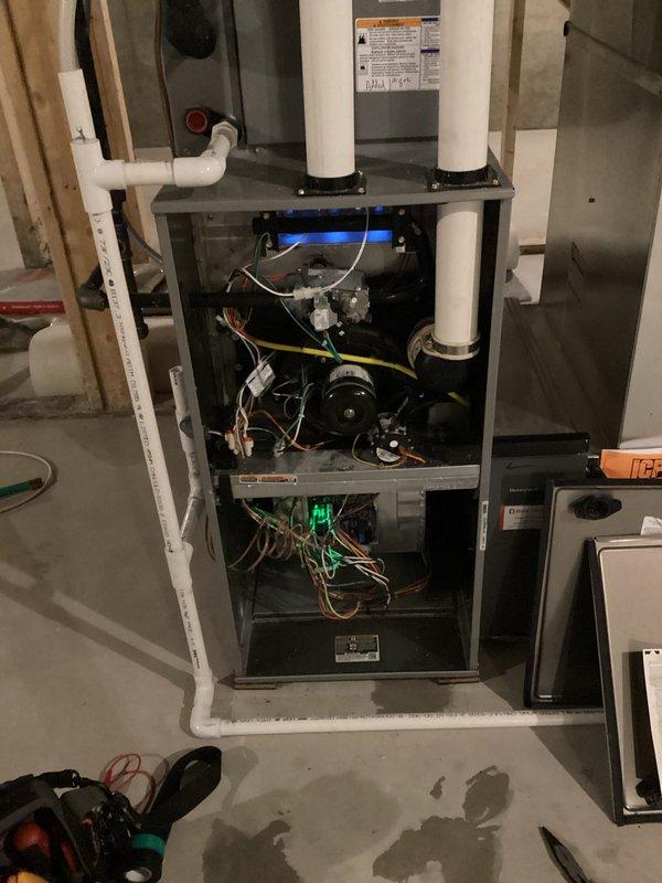 Responded to no-heat call on newer furnace unit. Diagnosed issue with ignition sequence - observed flame rollout during startup. Removed access panel to inspect components, found inducer motor failing to maintain proper draft. Replaced draft inducer assembly and verified proper ignition sequence with sustained blue flame. System now operating within normal parameters with appropriate airflow and combustion.