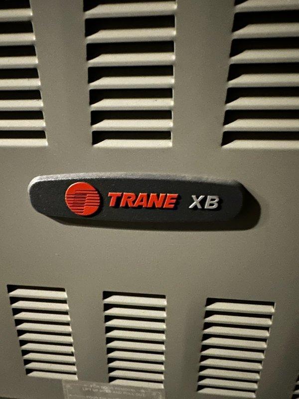 Performed routine maintenance service on Trane XB furnace. Removed access panel to inspect interior components, finding significant dust accumulation on blower motor assembly. Cleaned motor components and surrounding housing to improve system efficiency and prevent potential overheating issues.