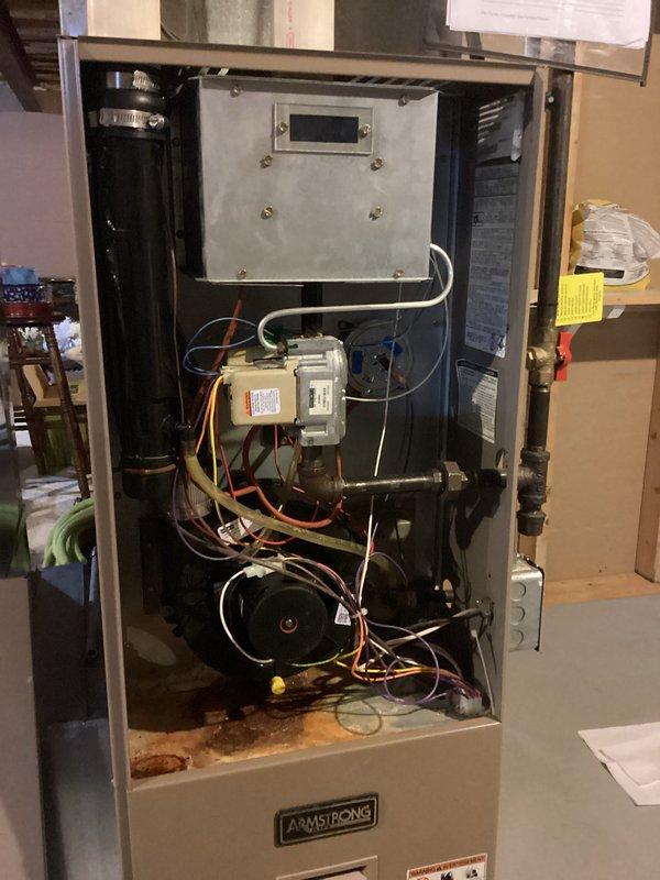 Performed diagnostic service on Armstrong furnace showing no heat operation. Removed access panel to inspect internal components including control board, gas valve assembly, and blower motor. Identified significant corrosion on electrical connections and wear on multiple components consistent with 10+ year old system. Cleaned electrical contacts, tested ignition sequence, and restored heating function. Recommended customer consider replacement options within next 1-2 heating seasons due to age-related component deterioration observed throughout system.