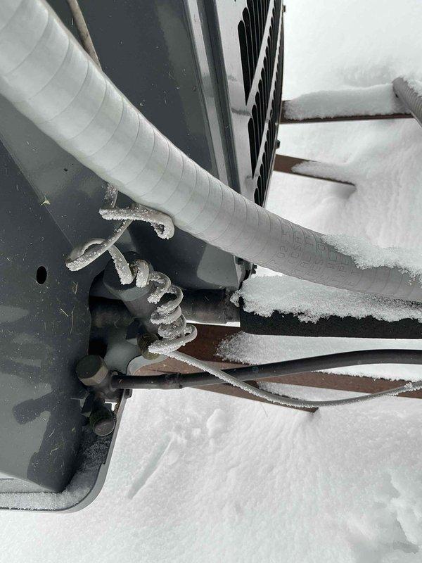 Conducted assessment of existing HVAC system with significant frost accumulation on refrigerant lines and coils of outdoor unit operating in snowy conditions. Recommended replacement of aging Bradford White water heater showing signs of deterioration at connection points, including pressure relief valve. Documented existing installation constraints in utility space to ensure proper sizing and configuration for replacement equipment.