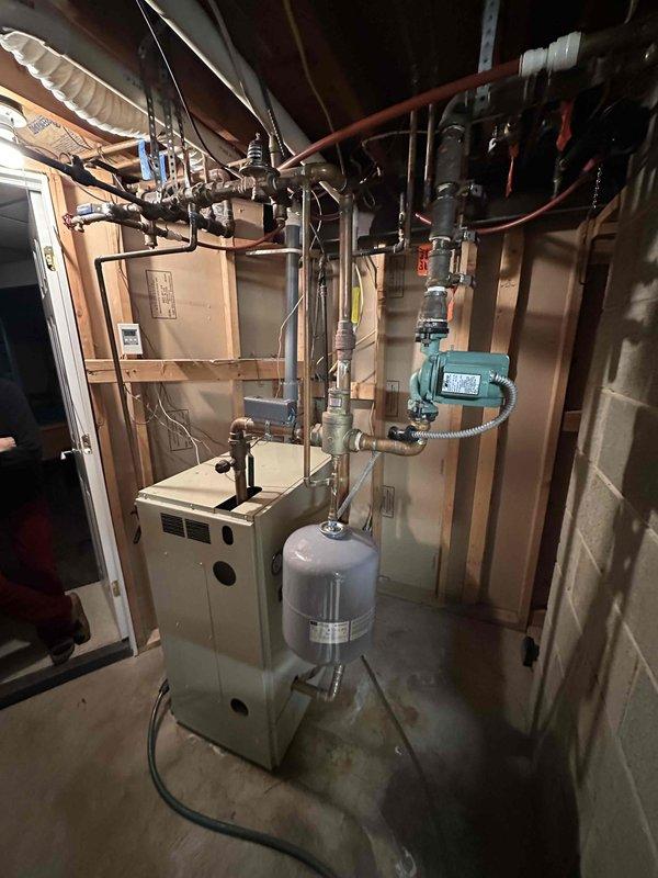Completed installation of a new furnace unit in basement utility room, including all necessary piping connections, expansion tank mounting, and integration with existing circulation system. Ensured proper setup of copper supply/return lines and verified all connections for optimal system performance.