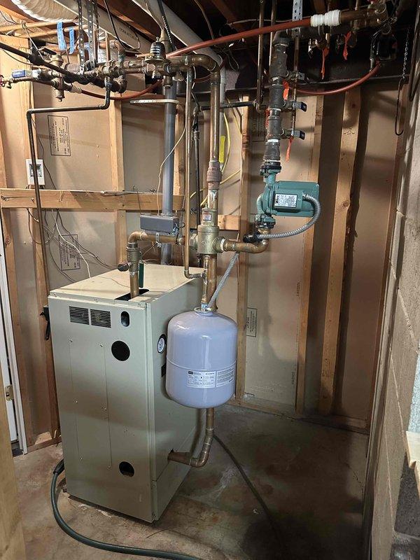 Completed installation of a new furnace unit in basement utility room, including all necessary piping connections, expansion tank mounting, and integration with existing circulation system. Ensured proper setup of copper supply/return lines and verified all connections for optimal system performance.