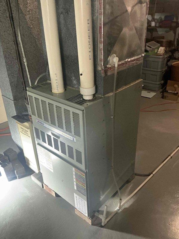 Conducted an assessment of an existing HVAC system in basement utility area, documenting a Pioneer unit with dual PVC ventilation pipes. Evaluation included inspection of the furnace cabinet, internal wiring components, drainage system, and connection points in preparation for replacement recommendation.