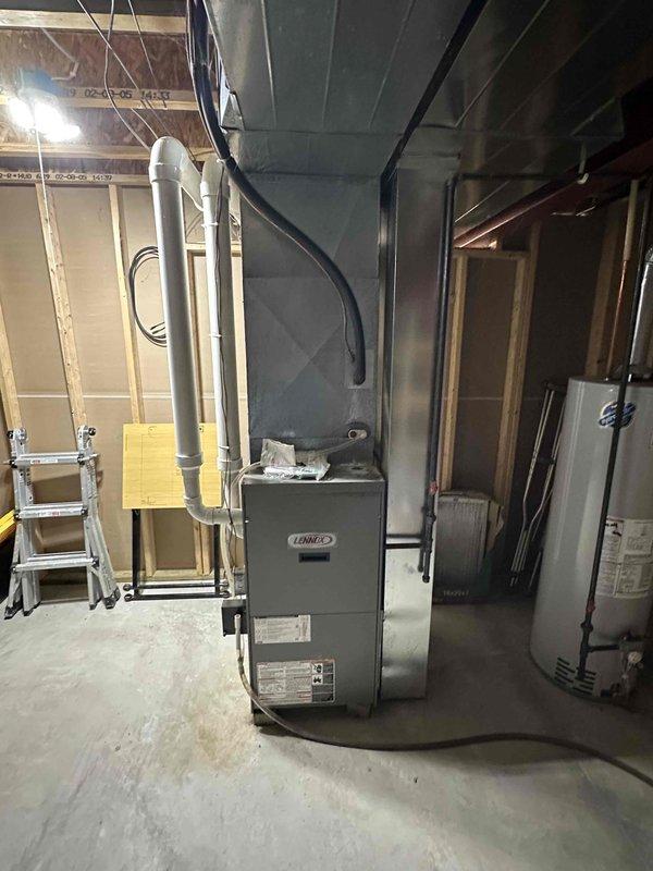 Completed installation of a new Lennox furnace system with proper ductwork connections in unfinished basement utility room. Installed new water heater with appropriate metallic ventilation piping, ensuring proper integration with existing mechanical infrastructure. Both units were properly secured and connected to the home's utility systems with all necessary ventilation components in place.