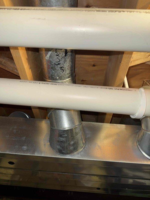 Conducted inspection of existing HVAC system in partially finished basement area. Documented current ductwork configuration including PVC ventilation pipes and galvanized metal ducting components. Evaluated ceiling space for new system installation constraints, noting transition between exposed utility ceiling and finished living areas with recessed lighting. Prepared estimate for complete system replacement based on observed structural conditions and space limitations.