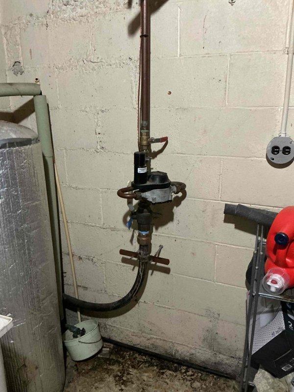 Inspected and serviced valve system in utility area. Identified corrosion on older piping sections below main valve assembly. Performed maintenance on pressure regulator and associated copper pipe fittings to ensure proper functioning of the plumbing system.