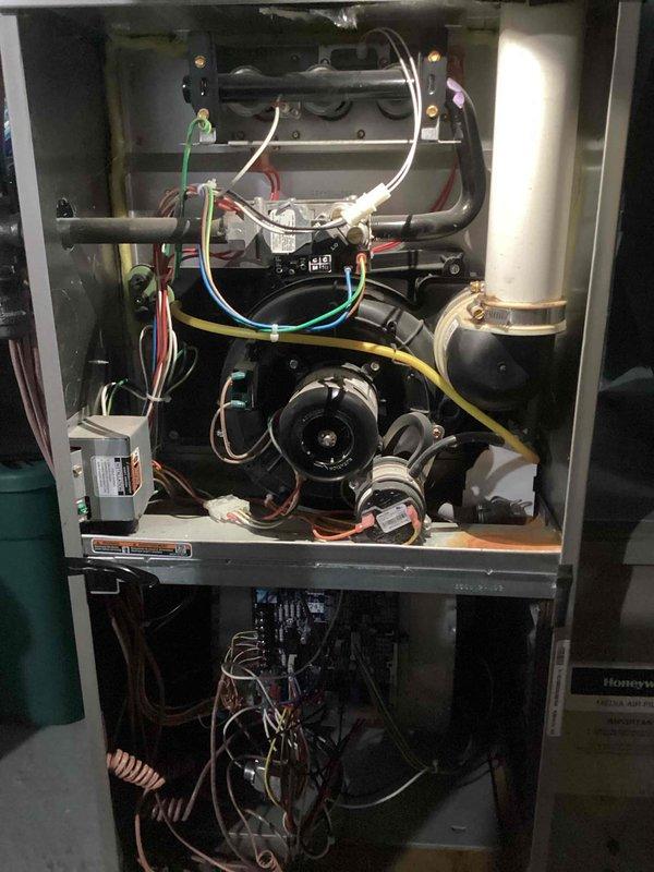 Performed routine maintenance on residential furnace system, including opening access panels to inspect internal components and electrical connections. Removed and examined ceramic ignition component which showed signs of wear and dust accumulation. Cleaned electrical terminals and checked all wiring connections (green, white, red, blue, and yellow) to ensure proper operation and system safety.