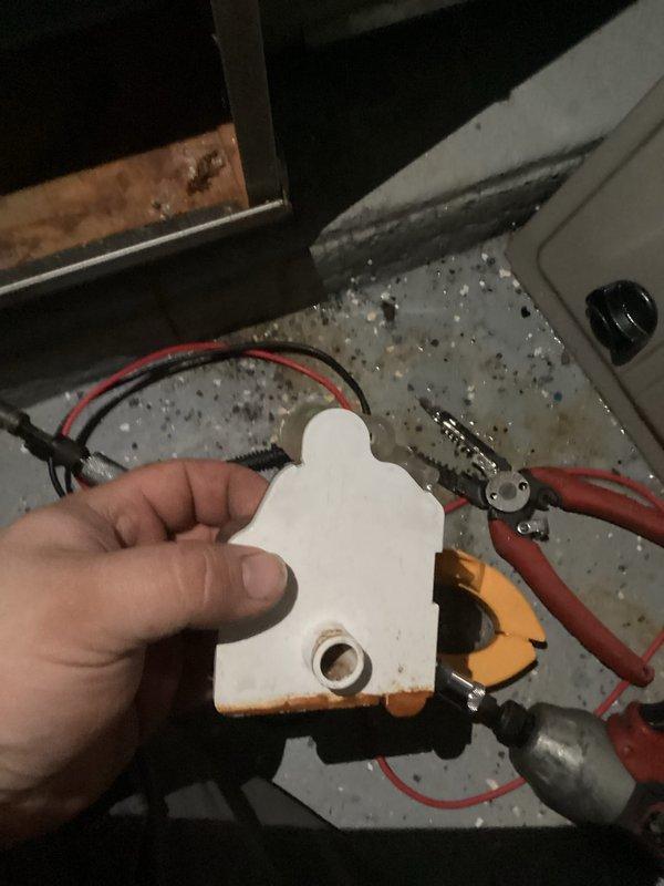 Performed routine maintenance on residential furnace system, including opening access panels to inspect internal components and electrical connections. Removed and examined ceramic ignition component which showed signs of wear and dust accumulation. Cleaned electrical terminals and checked all wiring connections (green, white, red, blue, and yellow) to ensure proper operation and system safety.