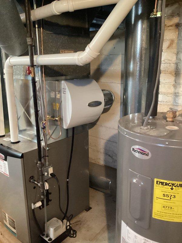 Completed installation of HVAC system with integrated IAQ components in basement mechanical room, including proper connection of ductwork, PVC venting, and installation of whole-house humidifier. System includes new Richmond water heater and furnace/air handler with all required mechanical connections, electrical wiring, and control systems properly installed and tested for optimal performance.