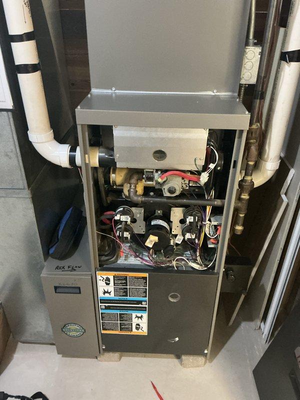 Completed prepaid maintenance service on residential gas furnace. Removed access panels to inspect internal components including control board, gas valve assembly, and electrical connections. System appears to be properly installed with appropriate PVC venting and accessible service clearances.