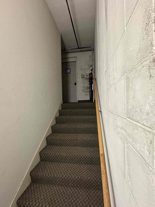 Conducted inspection of existing HVAC system located in basement service area accessible via narrow stairwell. Observed outdoor heat pump/AC unit showing signs of age with rusted fan hub and weathered components. Recommended complete system replacement due to deterioration and anticipated efficiency improvements.