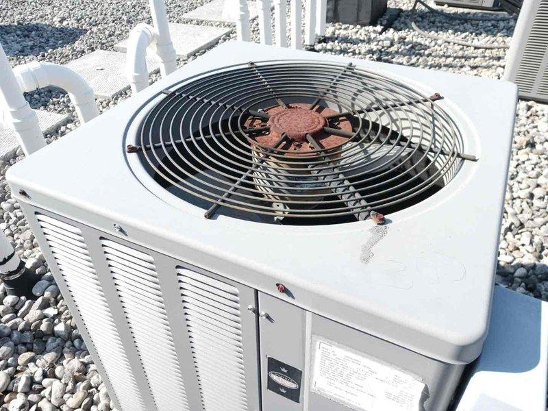 Conducted inspection of existing HVAC system located in basement service area accessible via narrow stairwell. Observed outdoor heat pump/AC unit showing signs of age with rusted fan hub and weathered components. Recommended complete system replacement due to deterioration and anticipated efficiency improvements.