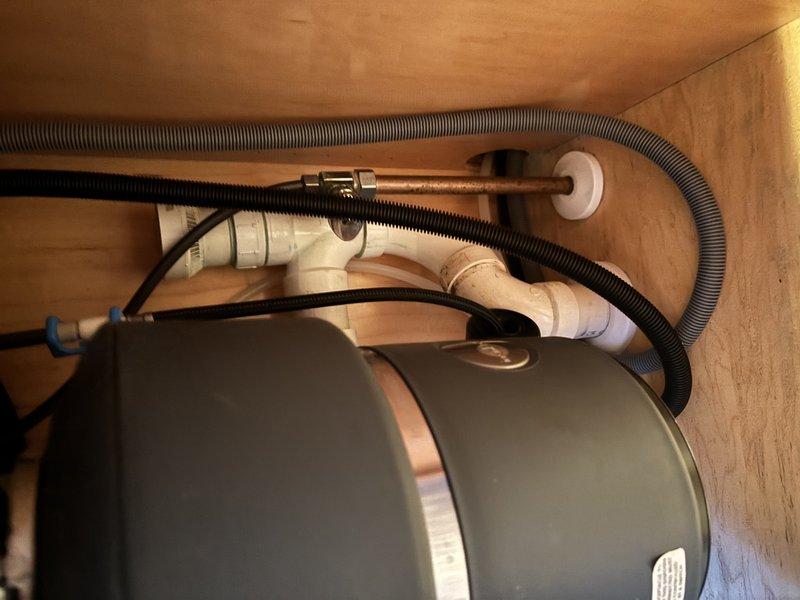 Completed inspection and service of shower/tub plumbing system. Examined drainage assembly including PVC piping, elbow joints, and flexible drain lines. Verified proper function of pump and supply lines with no leaks or damage detected in the enclosed wooden cabinet housing.