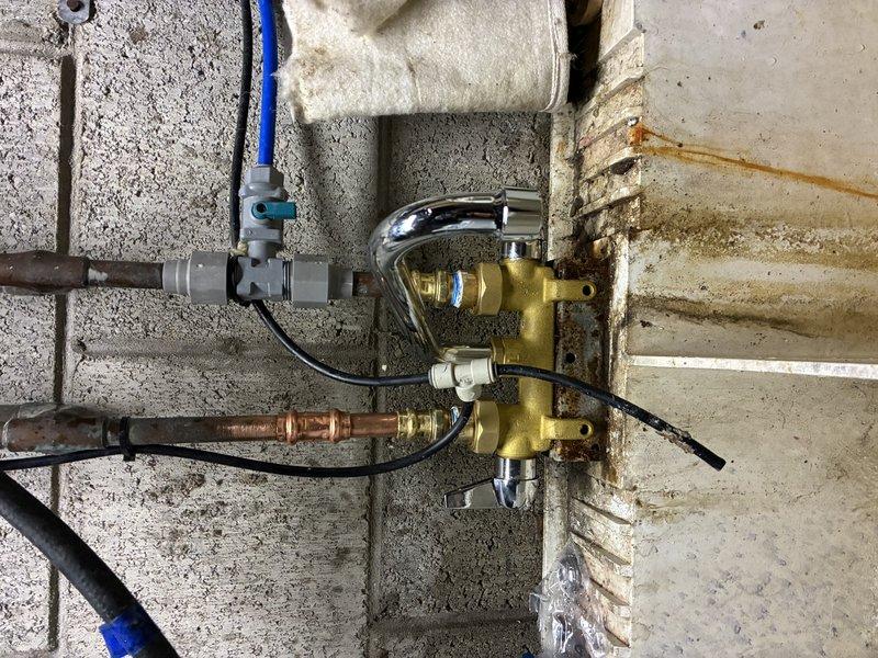Replaced corroded brass valve assembly on concrete block wall plumbing system. Installed new faucet and reconnected copper supply lines, PVC drainage, and all associated fittings. Tested for proper operation and confirmed cessation of previously observed rust-colored water leakage.