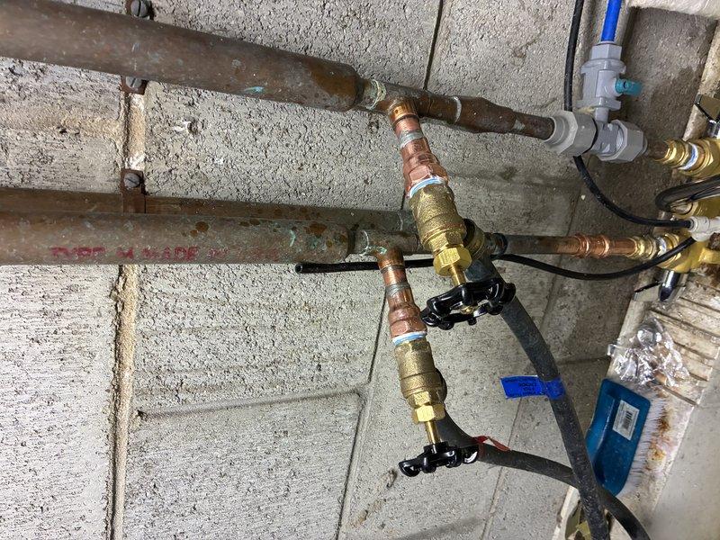 Replaced corroded brass valve assembly on concrete block wall plumbing system. Installed new faucet and reconnected copper supply lines, PVC drainage, and all associated fittings. Tested for proper operation and confirmed cessation of previously observed rust-colored water leakage.