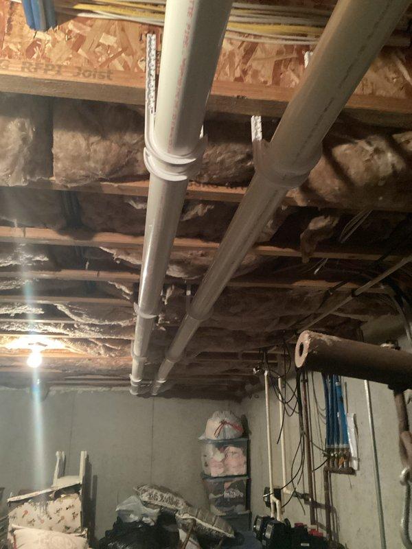 Performed inspection of basement furnace installation, noting proper mounting of the heating unit on concrete wall with functional digital display. Verified integrity of extensive copper piping network, checked circulation pump operation, and confirmed proper installation of PVC venting through ceiling joists. All components operating within normal parameters.