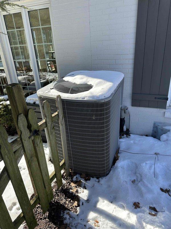 Conducted an assessment of existing HVAC system for potential replacement. Inspected aging water heater and mechanical components in utility room, noting confined installation space with concrete block walls and multiple connected pipes. Evaluated outdoor AC unit showing signs of weather exposure and snow accumulation, currently installed on concrete pad adjacent to residence. System replacement would require careful consideration of existing utility room constraints and proper sizing for the home's requirements.