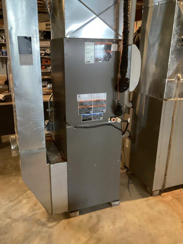 Successfully installed a complete HVAC system including a Goodman furnace with proper sheet metal ductwork connections in the utility room. System installation included mounting the digital thermostat control panel on the main living area wall and verifying all components were operational after installation.