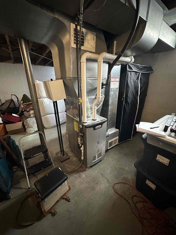 Conducted inspection of existing HVAC system in basement utility area. Evaluated aging furnace unit with PVC exhaust venting and associated ductwork for replacement. Documented current installation conditions including clearance requirements, existing connections, and potential installation challenges for proper system sizing and configuration recommendations.